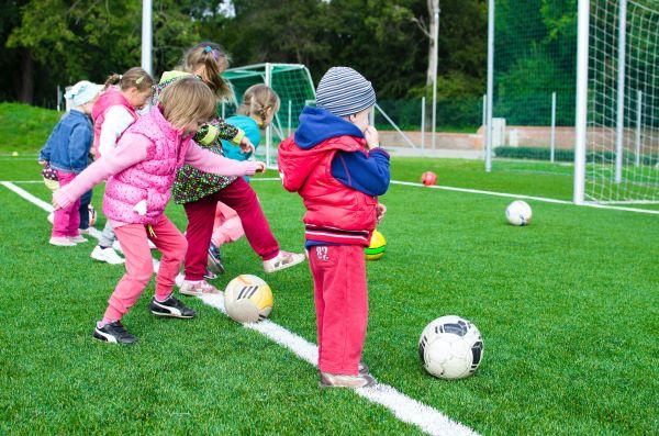 A photograph of young children playing football